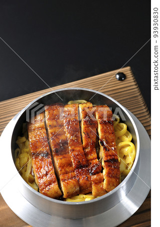 A bird's-eye view of a hot pot rice with grilled eel on a black background A bird's-eye view of a hot pot rice with grilled eel on a black background 93930830