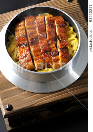 A bird's-eye view of a hot pot rice with grilled eel on a black background A bird's-eye view of a hot pot rice with grilled eel on a black background 93930831