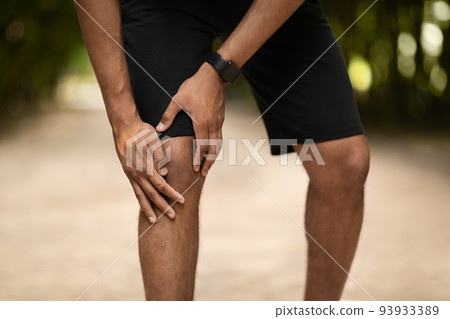 Cropped of portsman exercising in public park, touching injured ankle Cropped of portsman exercising in public park, touching injured ankle 93933389