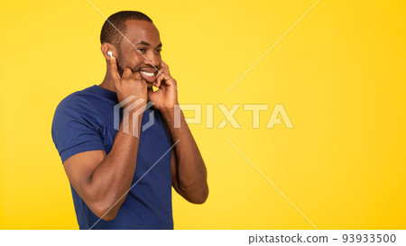 Happy Black Male Listening Music Wearing Earbuds Over Yellow Background 93933500