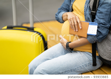 Unrecognizable pregnant woman travelling alone, copy space 93933665