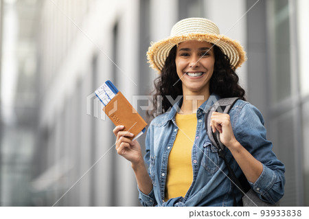 Closeup of cheerful pretty woman holding passport and tickets 93933838