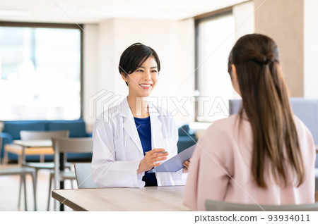 Female doctor interviewing a patient Female doctor interviewing a patient 93934011