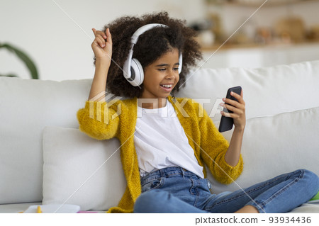 joyful african american school girl listening to music joyful african american school girl listening to music 93934436