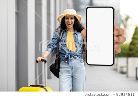 Excited pretty lady traveller showing smartphone, mockup Excited pretty lady traveller showing smartphone, mockup 93934611