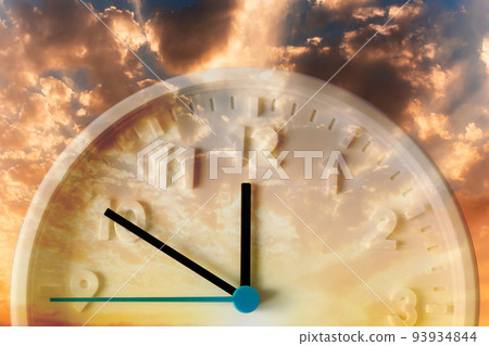 Golden cloudy sunset sky and close up of clock. Double exposure. Daylight Savings Time Concept 93934844