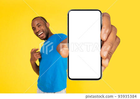 African Man Holding Large Phone Empty Screen Over Yellow Background 93935384