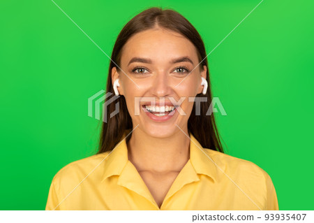 Headshot Of Lady Wearing Earbuds Listening To Music, Green Background Headshot Of Lady Wearing Earbuds Listening To Music, Green Background 93935407