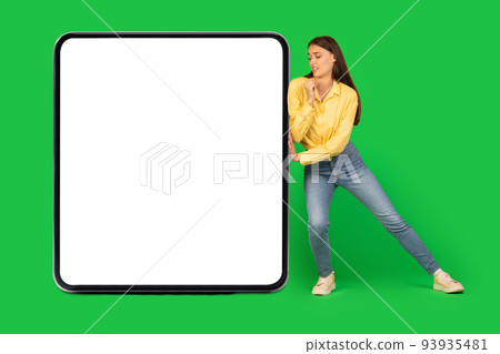 Woman Pushing Big Square Empty Gadget Screen Over Green Background Woman Pushing Big Square Empty Gadget Screen Over Green Background 93935481