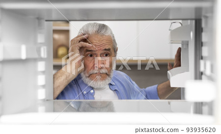 Portrait Of Hungry Elderly Man Searching For Food In Empty Fridge 93935620