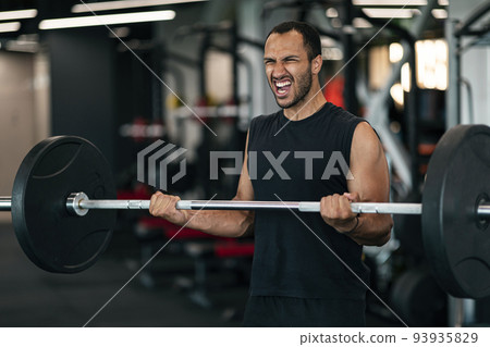 Black Athletic Man Screaming While Making Effort To Lift Barbell At Gym 93935829