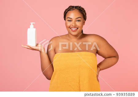 African American Lady Holding Dispenser Bottle Advertising Cosmetics, Pink Background African American Lady Holding Dispenser Bottle Advertising Cosmetics, Pink Background 93935889