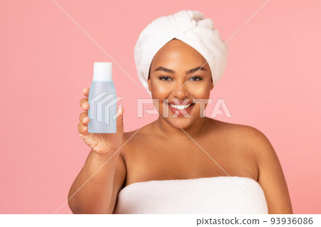 Happy African American Lady Showing Cosmetic Bottle Over Pink Background 93936086