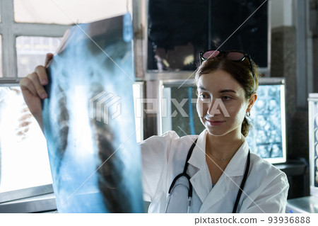 Doctor woman looking check up x-ray film in medical laboratory at hospital. 93936888