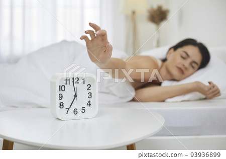 Sleepy woman snooze clock awaken in bed 93936899