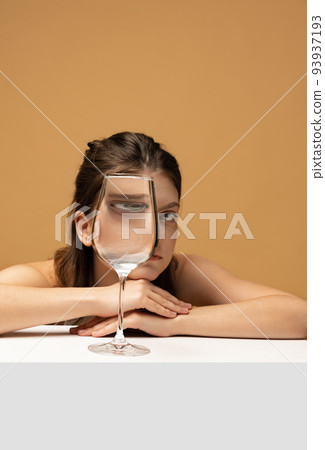 Modern art photography. Beautiful girl's face through wine glass. Object distortion, optical illusion. Minimalistic contemporary art. Modern art photography. Beautiful girl's face through wine glass. Object distortion, optical illusion. Minimalistic contemporary art. 93937193