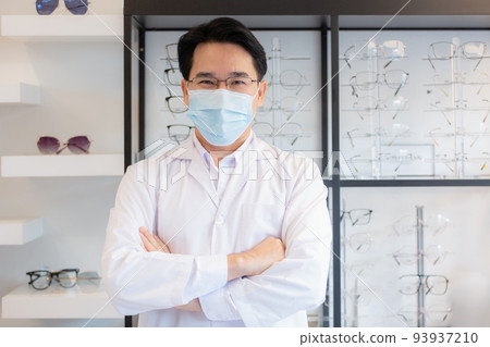 Man professional optician selling wear spectacles and protective face mask. 93937210