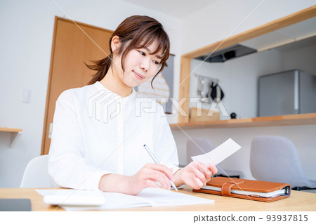 Young woman living room household account book Young woman living room household account book 93937815