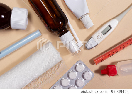 Bandage, medicine bottles, pills and a thermometer on a light beige background. Photos for medicine and pharmacy Bandage, medicine bottles, pills and a thermometer on a light beige background. Photos for medicine and pharmacy 93939404