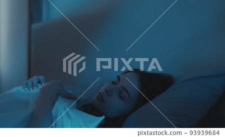 Vertical video. Good night. Sweet dreams. Sleeping woman. Relaxed calm lady in comfortable bed in dark bedroom with blue moonlight. 93939684