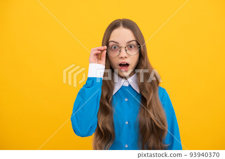Surprised teenage girl fix eyeglasses yellow background, surprise 93940370