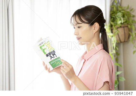 窗邊拿著外匯書籍的女人 93941047