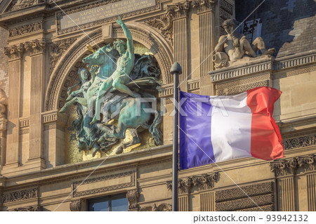 French flag winding and parisian architecture in Paris, France 93942132
