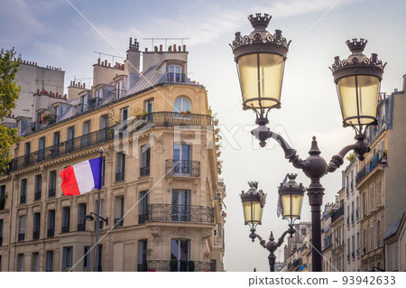 French flag winding and parisian architecture in Paris, France 93942633