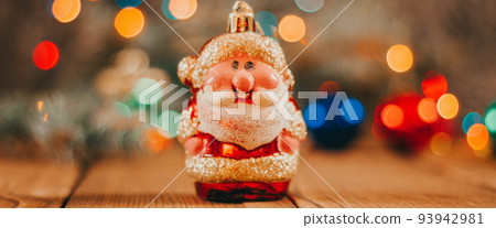 Christmas background with gift boxes, santa claus toy on wooden background with garland bokeh. Festive winter concept. Flat lay, copy space. photo banner Christmas background with gift boxes, santa claus toy on wooden background with garland bokeh. Festive winter concept. Flat lay, copy space. photo banner 93942981