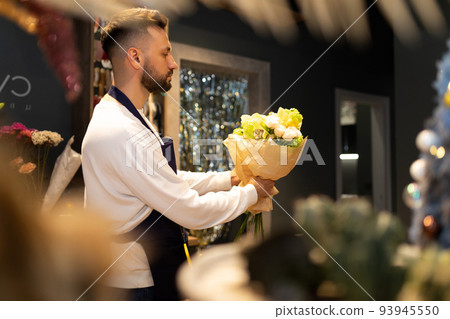 Bouquet designer in the workplace creates a composition of fresh flowers 93945550