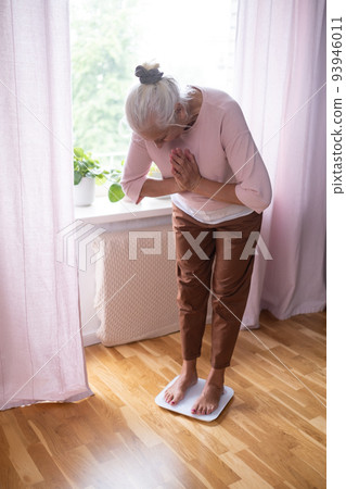 Woman stepping on floor scales, closeup. Weight control Woman stepping on floor scales, closeup. Weight control 93946011