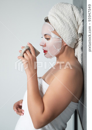 Facial care, a girl and a fabric mask on her face. Facial care, a girl and a fabric mask on her face. 93947849