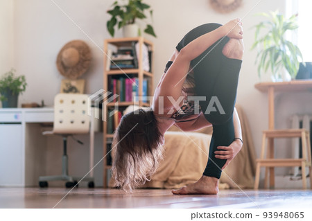 Woman practicing yoga lesson, doing stretcing exercise, working out, indoor Woman practicing yoga lesson, doing stretcing exercise, working out, indoor 93948065
