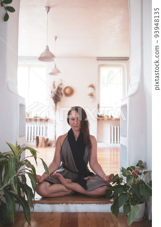 woman practicing yoga lesson, breathing, meditating, doing Padmasana exercise 93948135