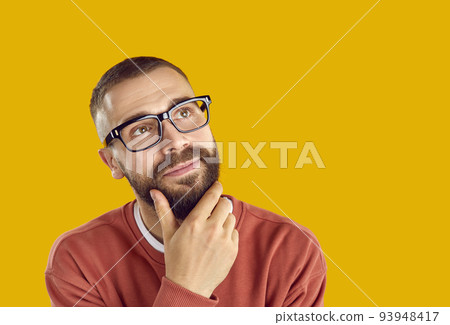 Young man in eyeglasses looking away at yellow copy space background and thinking Young man in eyeglasses looking away at yellow copy space background and thinking 93948417