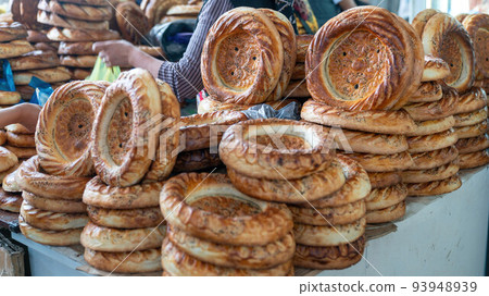 Naan circular and flat bread made in a tandoori oven, a central Asian custom, Osh local bazaar, Kyrgyzstan. Naan circular and flat bread made in a tandoori oven, a central Asian custom, Osh local bazaar, Kyrgyzstan. 93948939