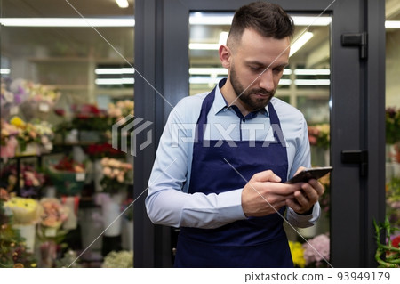 an employee of a floristic boutique takes orders through social networks via the Internet an employee of a floristic boutique takes orders through social networks via the Internet 93949179