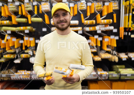 consultant recommends rollers and brushes for painting work in a hardware store 93950107