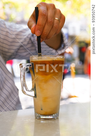 Ice latte coffee with a straw on the table. 93950742