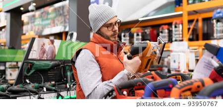buyer in a store for a choice of power tools for domestic household needs buyer in a store for a choice of power tools for domestic household needs 93950767