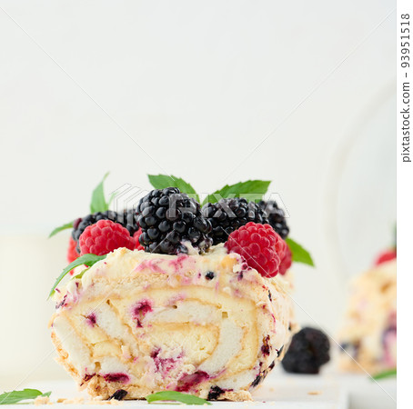 Baked meringue roll with cream and fresh fruits on a white wooden board, delicious dessert Baked meringue roll with cream and fresh fruits on a white wooden board, delicious dessert 93951518