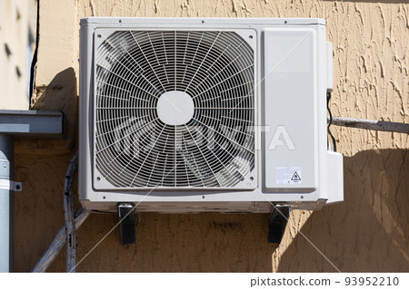 outdoor unit of a domestic air conditioner with a fan outside the building 93952210