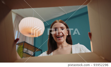 Happy young woman shopper unpacking cardboard - Stock Photo