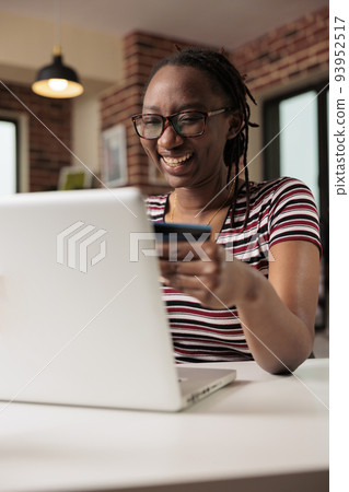 Happy shopaholic making purchase in internet store sale, holding credit card, online payment, electronic retail shopping. Smiling person buying products remotely using laptop, buyer paying for order Happy shopaholic making purchase in internet store sale, holding credit card, online payment, electronic retail shopping. Smiling person buying products remotely using laptop, buyer paying for order 93952517