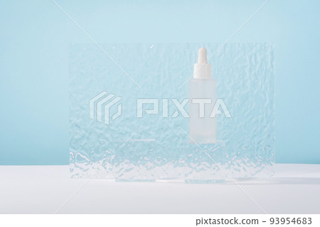 Serum cosmetic bottle with peptides and retinol on acrylic blocks on blue background. Hyaluronic acid cosmetics transparent fashion product packaging with stylish props. Serum beauty dropper Serum cosmetic bottle with peptides and retinol on acrylic blocks on blue background. Hyaluronic acid cosmetics transparent fashion product packaging with stylish props. Serum beauty dropper 93954683