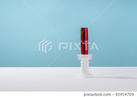 Red lipstick on roman marble column on blue background. Creative product stage mock up, cosmetic display podium platform or cosmetics product presentation, geometric stand Red lipstick on roman marble column on blue background. Creative product stage mock up, cosmetic display podium platform or cosmetics product presentation, geometric stand 93954709