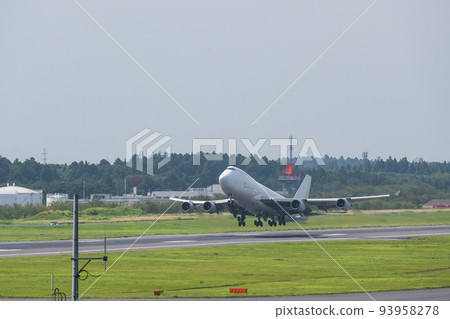 A white jumbo cargo plane taking off from the runway of Narita Airport into the white sky taken from the Aviation Museum 93958278