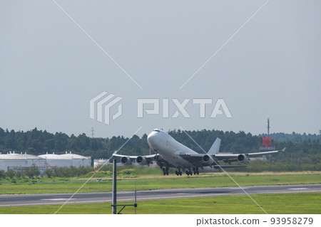 A white jumbo cargo plane taking off from the runway of Narita Airport into the white sky taken from the Aviation Museum 93958279