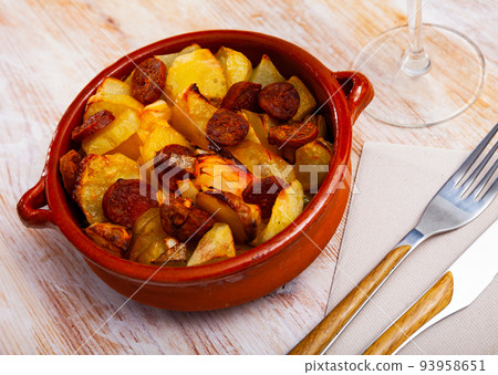 Potatoes with sliced chorizo sausage 93958651