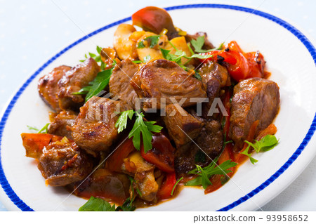 Cooked fried pork meat with peppers, mushrooms and greens 93958652